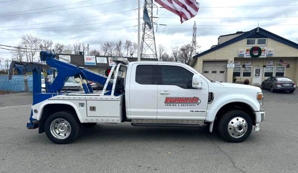 Blue and white tow truck in parking lot