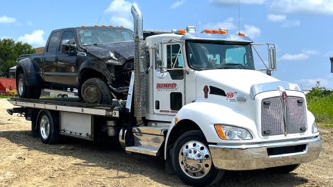 Damaged truck on white tow truck