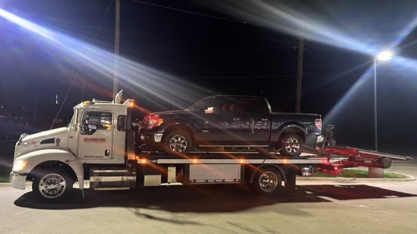 Black truck on flatbed tow truck