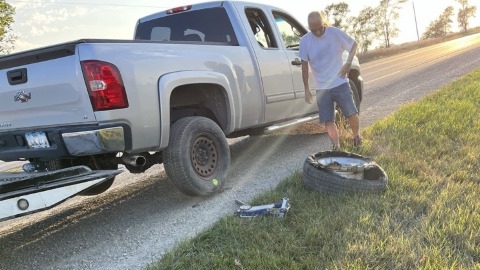 Truck with diver and tire on side of road